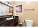 Modern bathroom with dark wood cabinets, granite countertop, a large mirror, and essential fixtures at 1375 Tuscana Ln # 1107, Davenport, FL 33896