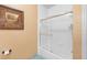 Clean bathroom with a shower and bathtub combo, white tile, and large shower door at 1375 Tuscana Ln # 1107, Davenport, FL 33896