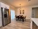 Well-lit dining room features a modern light fixture and a stainless steel refrigerator at 150 Marion Oakes Trl, Ocala, FL 34473
