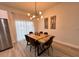 Well-lit dining room features a modern light fixture, fork art and a stainless steel refrigerator at 150 Marion Oakes Trl, Ocala, FL 34473