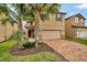 Two-story house with tan siding, brick accents, and a two-car garage at 1505 Mumbai Way, Kissimmee, FL 34747