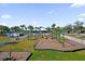 Community playground featuring slides, swings, mature palm trees, and a grassy lawn at 15157 Sunrise Grove Ct, Winter Garden, FL 34787