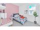 Cozy bedroom with a bed, desk, and pink accent wall at 157 Pineywoods St, St Cloud, FL 34769