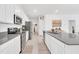 Modern kitchen boasts white cabinets, gray countertops, and stainless steel appliances at 157 Pineywoods St, St Cloud, FL 34769