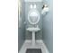 Charming half-bath featuring a pedestal sink, oval mirror, and stylish decor at 179 Hillcrest Dr, Oviedo, FL 32765