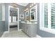 Elegant primary bathroom with double vanity, granite counters, and shuttered window at 179 Hillcrest Dr, Oviedo, FL 32765