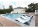 Backyard pool featuring lounge chairs and a detached garage at 179 Hillcrest Dr, Oviedo, FL 32765