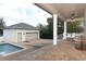 Pool and patio area, including a detached garage, covered porch, and a seating swing at 179 Hillcrest Dr, Oviedo, FL 32765