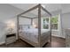 Bedroom with wooden canopy bed and dark hardwood floors at 202 E South St # 1048, Orlando, FL 32801