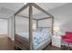 Bedroom with wooden canopy bed and pink chair at 202 E South St # 1048, Orlando, FL 32801