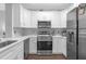 Modern white kitchen with stainless steel appliances and tile backsplash at 202 E South St # 1048, Orlando, FL 32801