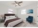 Primary bedroom with ceiling fan, a sitting area, and dark bedding at 2414 Herbison Dr, Orlando, FL 32810