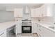 Modern white kitchen with stainless steel appliances and hexagon backsplash at 2414 Herbison Dr, Orlando, FL 32810