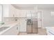 Modern white kitchen with stainless steel appliances and a large refrigerator at 2414 Herbison Dr, Orlando, FL 32810