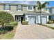 Exterior view of a two-story townhome with a two-car garage and landscaping at 2646 River Landing Dr, Sanford, FL 32771