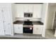 Modern kitchen features white cabinets, stainless steel appliances, and gray countertops at 2713 Runners Cir, Clermont, FL 34714