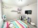 This bedroom features a striped bed, bright wall decor, and shelves for displaying toys, creating a bright and lively space at 2931 Top Water Way, Kissimmee, FL 34746