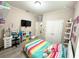 Bright bedroom featuring a striped bed, a desk area, and shelves adorned with toys and decorative items at 2931 Top Water Way, Kissimmee, FL 34746