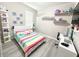 This bright bedroom has a colorful striped bed, bright wall decor, and shelves for displaying toys and collectibles at 2931 Top Water Way, Kissimmee, FL 34746