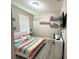 Charming bedroom featuring a rainbow-striped bed, decorative shelves, and a bright, airy feel at 2931 Top Water Way, Kissimmee, FL 34746