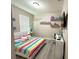 Bedroom with striped bedding, decorative wall decor and a tv mounted on the wall at 2931 Top Water Way, Kissimmee, FL 34746