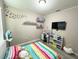 This bedroom features a striped bed, bright wall decor, and shelves for displaying toys, creating a bright, inviting space at 2931 Top Water Way, Kissimmee, FL 34746