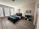 Modern bedroom featuring wood flooring, minimalist decor, and bright, natural light from the windows at 2931 Top Water Way, Kissimmee, FL 34746