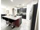 A modern kitchen with a large center island and black bar stools. Stainless steel appliances are included at 2931 Top Water Way, Kissimmee, FL 34746
