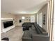 Open living room with a large gray sectional sofa, tile flooring, and natural lighting at 2931 Top Water Way, Kissimmee, FL 34746
