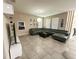 Spacious living room with tile flooring, modern lighting and a large gray, sectional sofa at 2931 Top Water Way, Kissimmee, FL 34746