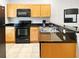 Kitchen with light wood cabinets and black appliances at 3002 Red Ginger Rd, Kissimmee, FL 34747