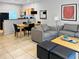 Open living and dining area with gray couches and wooden dining table at 3002 Red Ginger Rd, Kissimmee, FL 34747