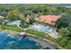 Aerial view of pools with sun loungers and umbrellas, next to lake and lush greenery at 3002 Red Ginger Rd, Kissimmee, FL 34747