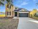 Two-story house with stone accents, a black garage door, and a well-manicured lawn at 3124 Oak Brook Ln, Eustis, FL 32736