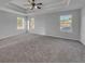 Main bedroom with neutral carpet, high ceilings, and multiple windows at 3124 Oak Brook Ln, Eustis, FL 32736