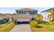 Two-story house with gray siding, open garage, and driveway at 361 Preserve Pointe Blvd, Davenport, FL 33837