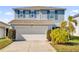Two-story house with gray siding, white garage door, and landscaping at 361 Preserve Pointe Blvd, Davenport, FL 33837