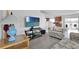 Living room with gray flooring, floral couches, and a large TV at 361 Preserve Pointe Blvd, Davenport, FL 33837
