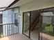 Relax on this balcony with sliding glass doors offering views of the wood stairs and lush landscape at 4826 Marks Terrace # 389, Orlando, FL 32811