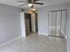 Bedroom with ceiling fan, mirrored closet doors, open closet, and neutral color scheme at 4826 Marks Terrace # 389, Orlando, FL 32811