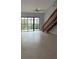 Spacious living room featuring light tile flooring and a wooden staircase leading to the second floor at 4826 Marks Terrace # 389, Orlando, FL 32811