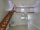 Open-concept living room boasts a wood staircase, ceiling fan, and views to the kitchen at 4826 Marks Terrace # 389, Orlando, FL 32811