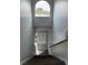 View looking down carpeted staircase with large, arched window at 4826 Marks Terrace # 389, Orlando, FL 32811