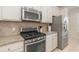 Well-equipped kitchen featuring stainless steel appliances, granite counters and ample cabinet space at 508 Zamora Way, Davenport, FL 33837