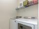 Efficient laundry room with modern washer and dryer units and overhead shelving at 508 Zamora Way, Davenport, FL 33837