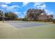 Outdoor community tennis court with well-maintained green and gray surface and surrounding trees at 508 Zamora Way, Davenport, FL 33837