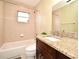 Bathroom boasts a granite countertop, dark wood cabinet, and a tub with tiled surround at 5403 Moxie Blvd, Orlando, FL 32839