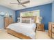 Spacious Primary bedroom with light wood furniture and blue walls at 5999 Lake Pointe # 609, Orlando, FL 32822