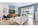 Open living room with white sofa, teal armchair, and sliding glass doors to backyard at 664 Preston Cove Dr, St Cloud, FL 34771