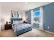 Guest bedroom with a blue bed frame, window with curtains, and modern wall art at 676 Preston Cove Dr, St Cloud, FL 34771